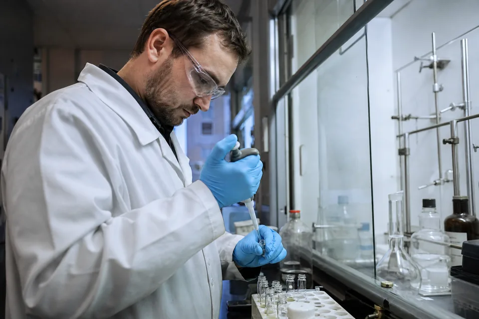 Laborantka pipetuje próbkę w laboratorium kontroli jakości zakładu chemicznego